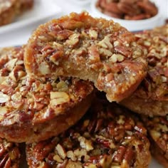 a pile of pecan cookies sitting on top of a plate next to other desserts