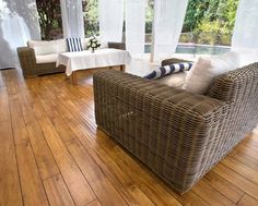 a living room with wooden floors and wicker furniture