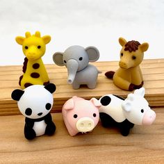 small toy animals sitting on top of a wooden table