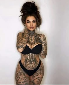 a woman with tattoos on her body posing for the camera