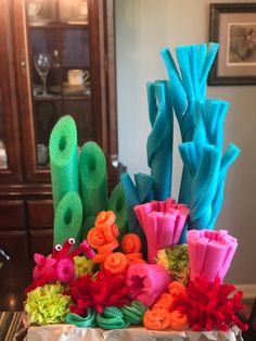 an arrangement of fake flowers in a vase on a table