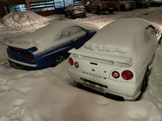 two cars covered in snow parked next to each other