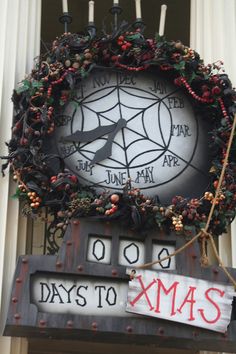 a clock that is on the side of a building with christmas decorations hanging from it's sides