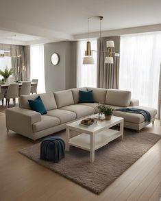 a living room filled with furniture next to a dining room table and window covered in curtains