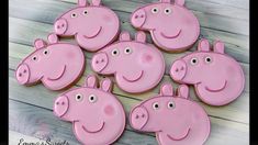 twelve pink peppa pig cookies on a wooden table