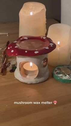 three lit candles sitting next to each other on top of a wooden table with the words mushroom wax melter