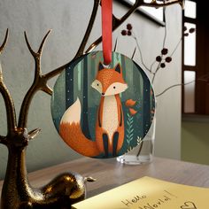 a christmas ornament with an image of a fox in the woods on it