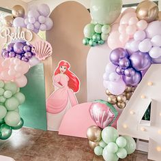 the balloon arch is decorated with mermaid balloons and princess ariel from disney's little mermaid