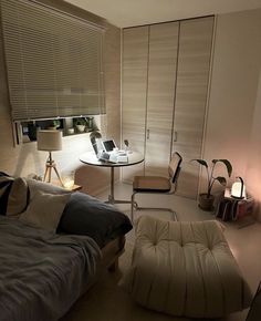 a bedroom with a bed, desk and laptop on the table in front of it