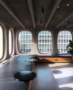 there are three large windows in the room that overlooks the city and is made of concrete