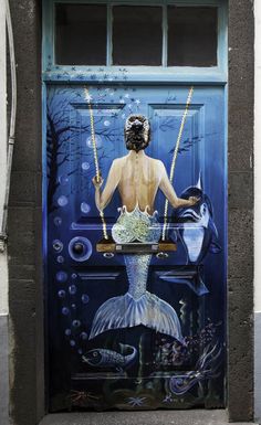 there is a painting on the door of a building that has a mermaid in it