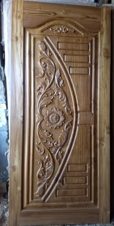 an intricate carved wooden door in the process of being made into a piece of wood