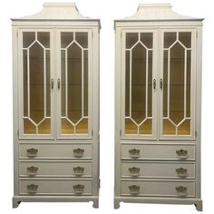 two tall white china cabinets with glass doors