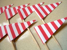 several red and white striped flags sitting on top of a table