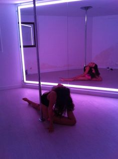 a woman sitting on the floor in front of a mirror