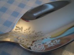 a silver spoon sitting on top of a blue and white checkered table cloth