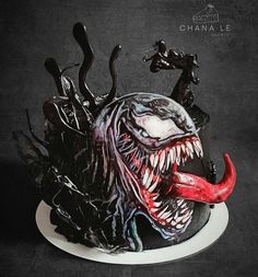 a cake decorated to look like a monster with sharp teeth and large fangs on it's head