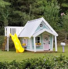 a little house with a slide in the front and a yellow slide next to it