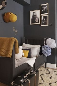 a bedroom with black walls and pictures on the wall