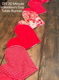 valentine's day table runner made out of fabric hearts on a wooden floor with text overlay that says diy 20 minute valentine's day table runner