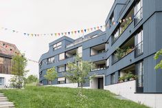 an apartment building with several balconies on the second floor and flags flying in the air