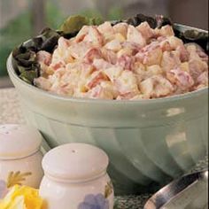 a bowl full of food sitting on top of a counter next to two salt shakers