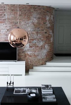 a living room filled with furniture and a brick wall