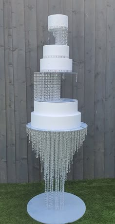 a three tiered cake with icing hanging from it's sides on grass