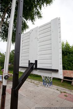 a basketball hoop is attached to the backboard of a white box on a sidewalk