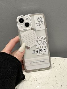 a person holding up a cell phone case with the words happy on it and flowers