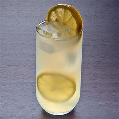 a glass filled with lemonade on top of a wooden table