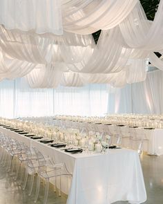 a banquet hall with tables and chairs covered in white draping