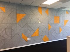 an office cubicle with orange and grey geometric wallpaper