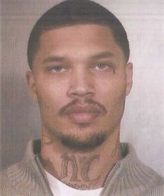 a man with tattoos on his neck and chest is looking at the camera while wearing a sweater