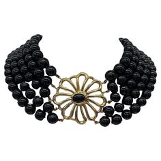 Make a bold statement with the Tiffany & Co. Paloma Picasso Onyx & Gold Necklace. Featuring sleek onyx beads accented with gold, this 14-inch necklace exudes contemporary elegance and sophistication. Designed by Paloma Picasso, it captures the essence of modern luxury and artistic expression, making it a versatile accessory for any occasion. Total Weight: 156.50g Clasp Size: 38mm x 38.8mm Length: 14" NS008 Luxury Black Necklaces With Gold Beads, Luxury Black Necklace With Polished Beads, Luxury Statement Black Bead Necklaces, Luxury Statement Onyx Necklace, Luxury Black Onyx Beaded Necklace, Paloma Picasso, Tiffany And Co, Onyx Bead, Paloma