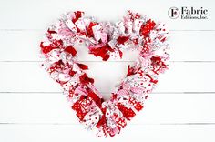 a red and white heart shaped wreath made from fabric