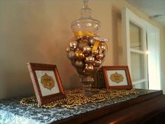 two framed pictures are sitting on top of a dresser next to a vase with ornaments in it