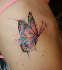 a woman's stomach with a colorful butterfly tattoo on it