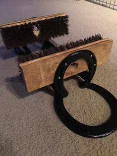 a pair of scissors sitting on top of a wooden box filled with brooms next to a brush holder