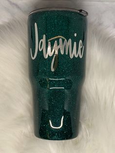 the name jammie is written on a green glittered tumbler