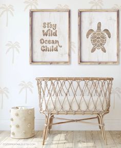 two framed pictures hang on the wall above a baby crib with a turtle in it