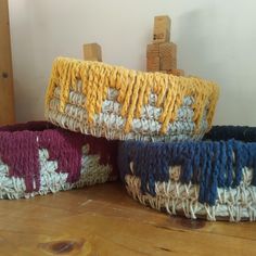 three woven baskets sitting on top of a wooden table