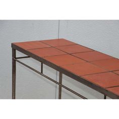 an orange tiled table with metal legs