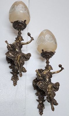 pair of antique brass and glass wall sconces with cherubs on them