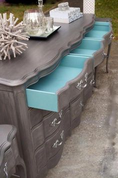 an old dresser has been painted blue and gray with silver trimmings on it