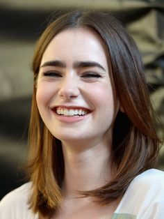 a woman with long hair smiling at the camera