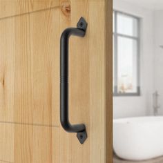 an image of a door handle on the side of a wooden door with a bathtub in the background