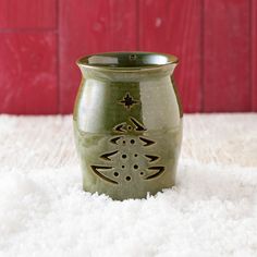 a green vase sitting on top of a white rug