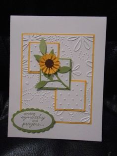 a white card with a yellow flower on it