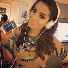 a woman wearing headphones and holding a cell phone